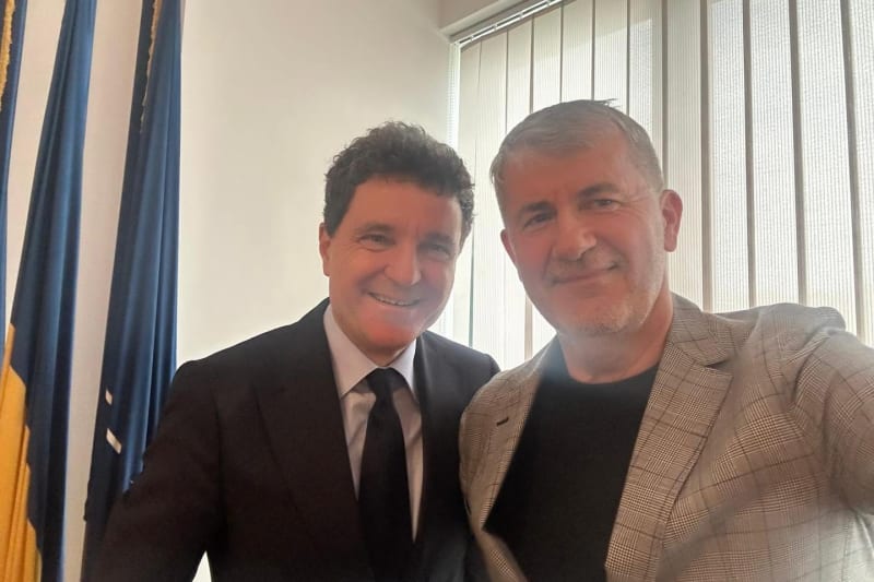 Valeriu Iftime alături de un invitat, într-un birou cu drapele