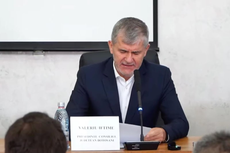 Valeriu Iftime la masa de ședință a Consiliului Județean, în fața plăcuței cu numele și funcția