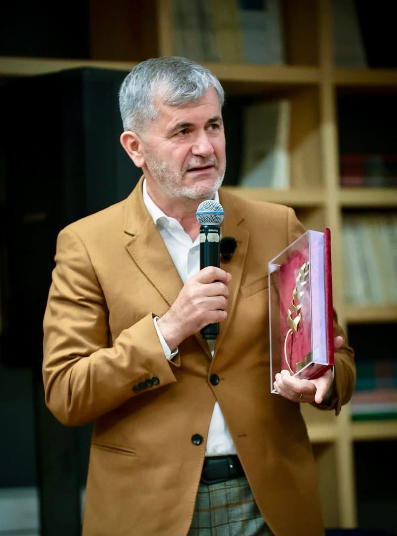 Valeriu Iftime vorbind la microfon, ținând o distincție