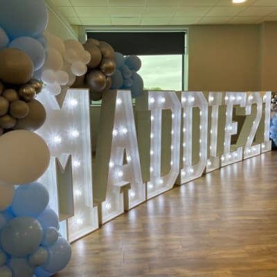 Grass Backdrop With Draped Flowers And Led Letter For A Christening Hire