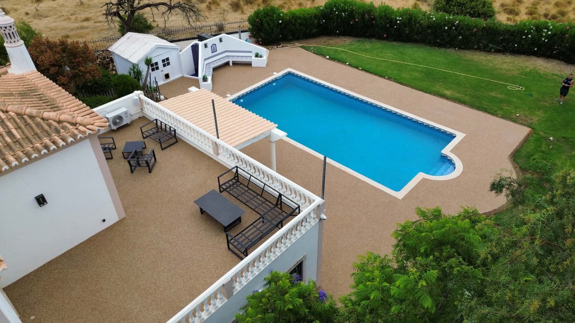 Finished resin bound swimming pool surround, pathways and terrace at a villa in Albufeira, Algarve, Portugal, installed by Bespoke Resin.