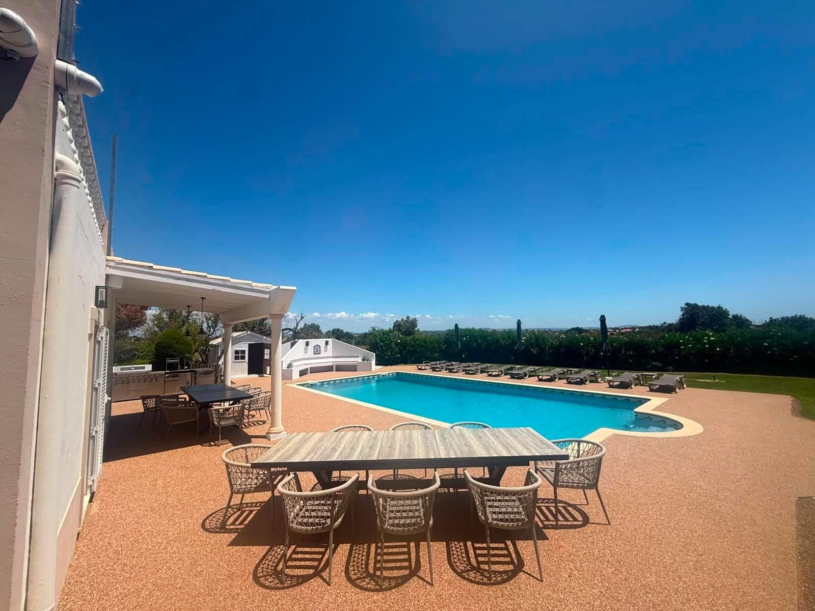 Finished resin bound pool terrace and outdoor dining area at a villa in Albufeira, Algarve, Portugal, completed by Bespoke Resin.