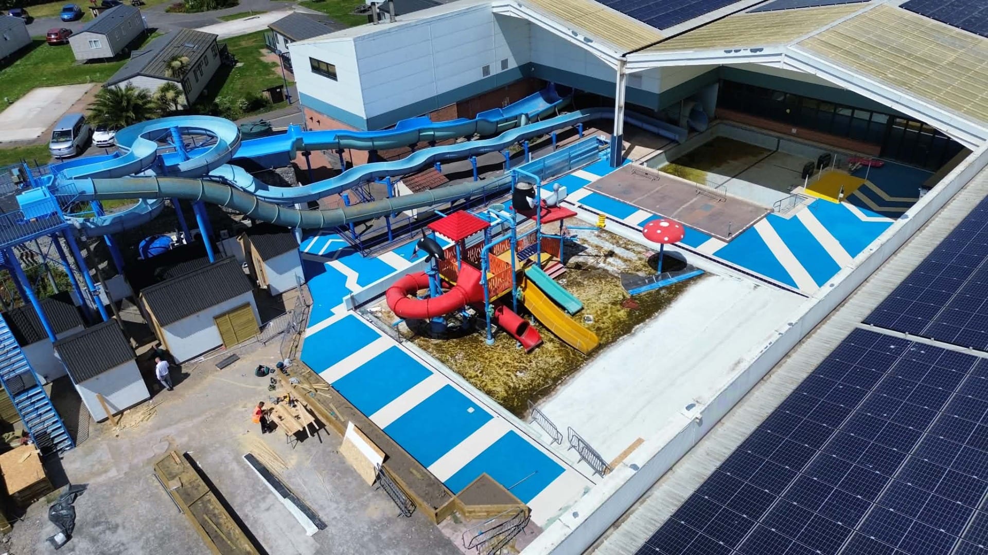 Bespoke blue and white resin bound surfacing with chevron design around the splash park at Unity Holiday Park, Somerset