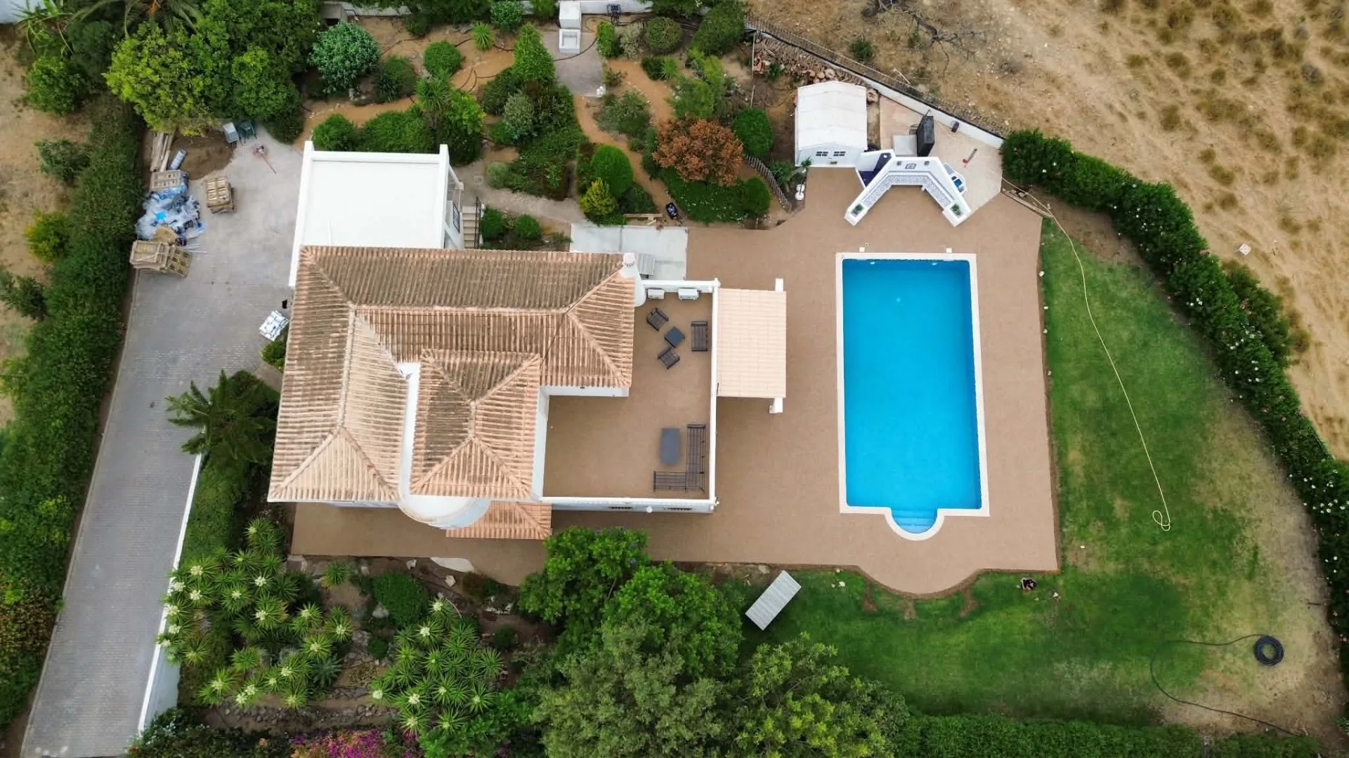 Aerial view of a completed resin bound pool surround, terrace and pathways at a villa in Albufeira, Algarve, installed by Bespoke Resin.
