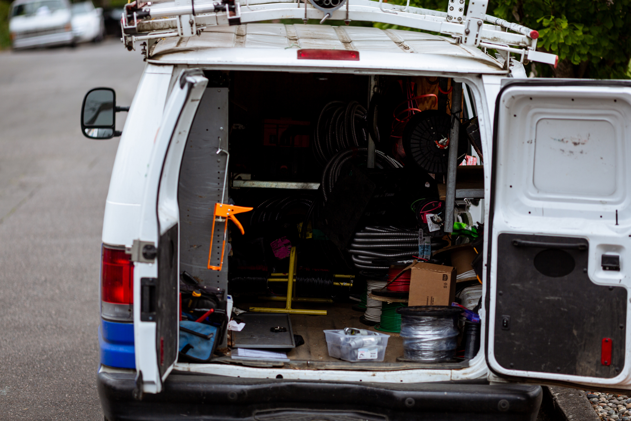 Contractor work van loaded with power tools and equipment parked at a sunny Florida job site
