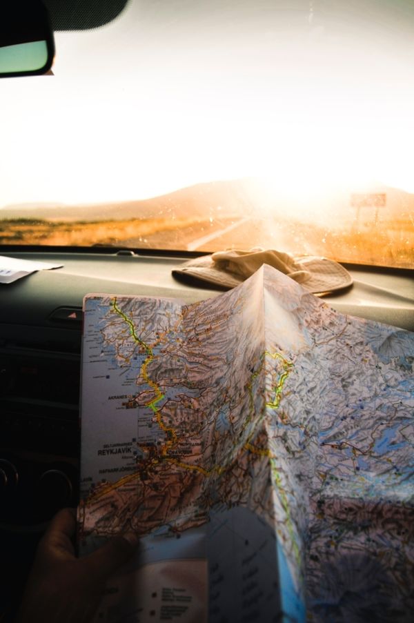 An open map on the dashboard of a car