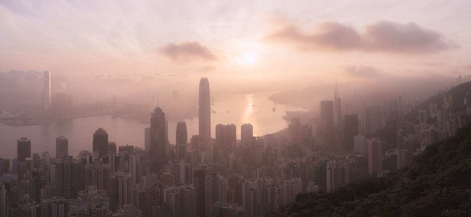 View of Victoria Harbour skyline at sunrise from Lugard Road Lookout on Victoria Peak in Hong Kong.