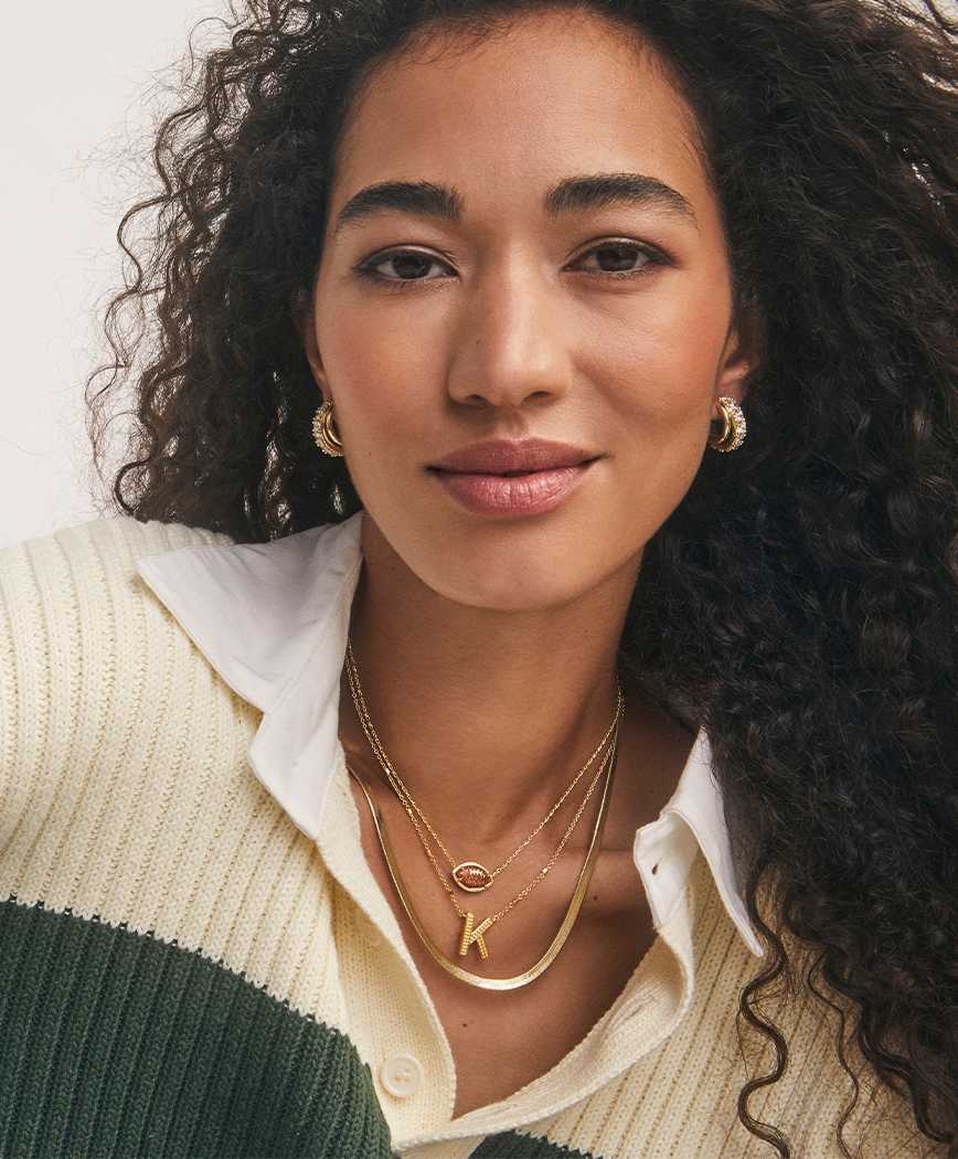 woman in cream sweater wearing Kendra Scott gameday bestsellers