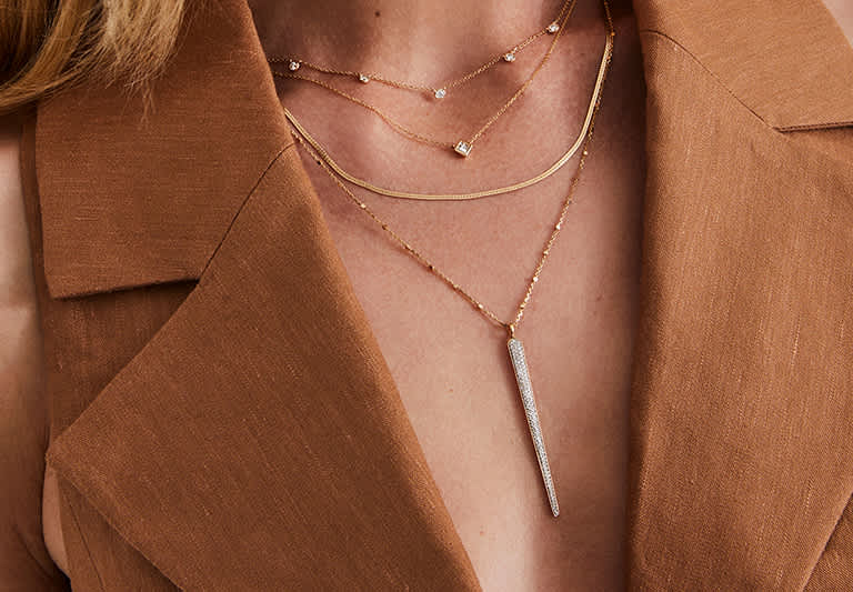 Model wearing multiple chain necklaces