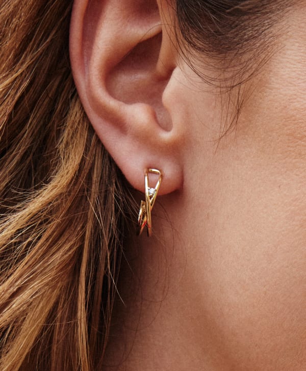 close up of women ear wearing gold and diamond hoop earring