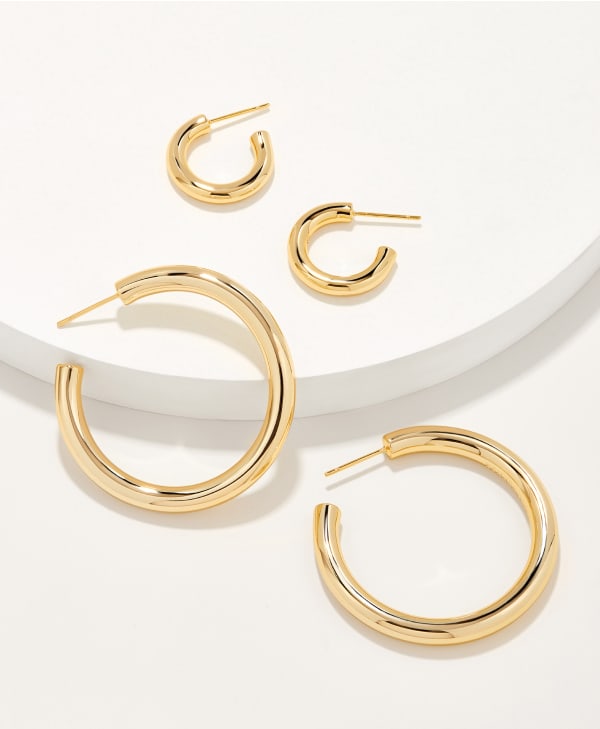 laydown image of gold hoop and gold huggie set