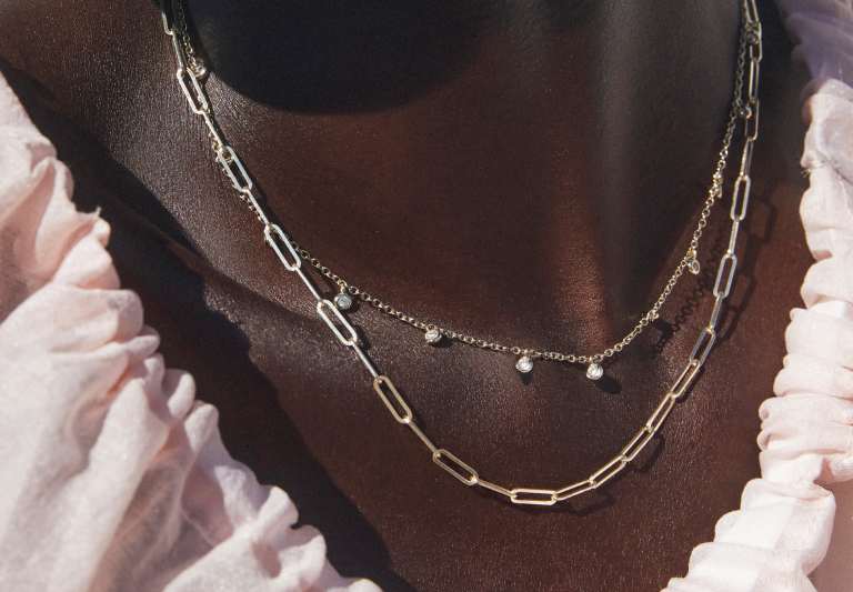 Model wearing multiple chain necklaces
