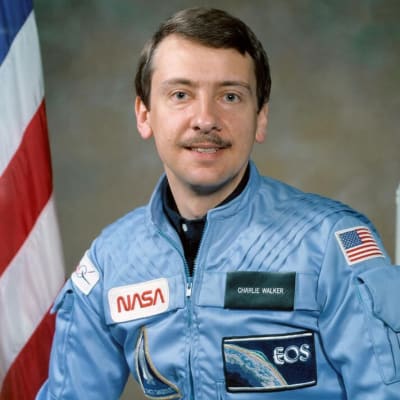 Astronaut Charles Walker with a model of the space shuttle