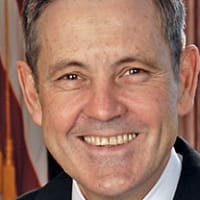 Headshot of Bob Cabana in front of a U.S. flag and space shuttle model