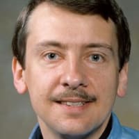 Astronaut Charles Walker with a model of the space shuttle