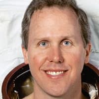 Tom Jones headshot with American flag in the background