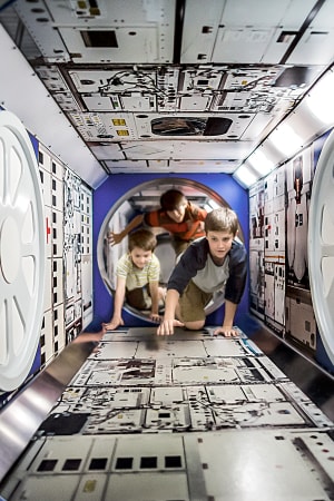 Children crawling through the ISS Tube