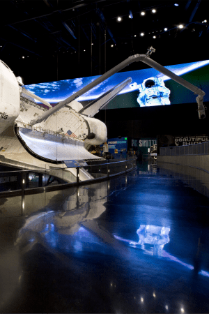 The orbiter Atlantis with a digital screen backdrop of the orbital sunrise inside the Space Shuttle Atlantis® exhibit at Kennedy Space Center Visitor Complex.