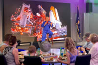 Astronaut talking to a group of visitors siting at a table during Chat With An Astronaut at Kennedy Space Center
