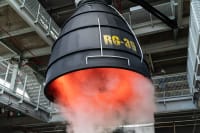 A billow of steam escapes from the nozzle of a hanging engine. Red light glows inside the nozzle, and the word "RG-39" is painted on in yellow across the black nozzle.