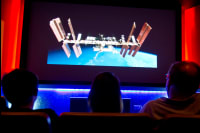 Audience members watching a Mission Status Briefing