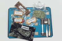 A place mat with utensils and vacuum sealed food that is eaten in space