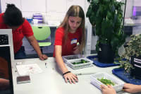 Student weighing plants in a lab