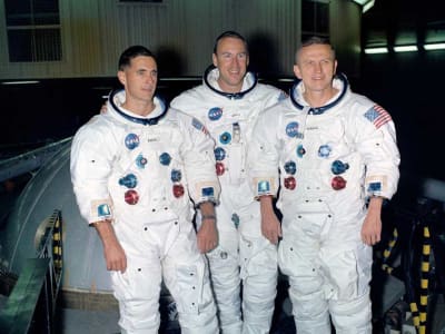 Three Apollo 8 crew members posing for a photo wearing their spacesuits