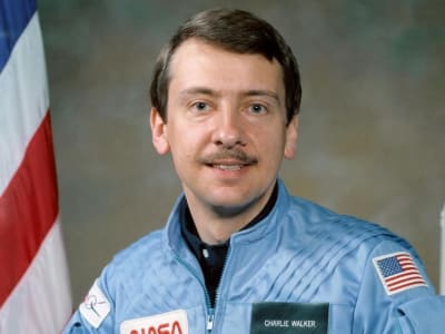 Astronaut Charles Walker with a model of the space shuttle