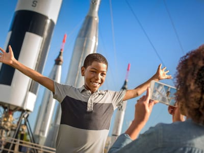 Mom taking a picture of her son outside of the rocket garden