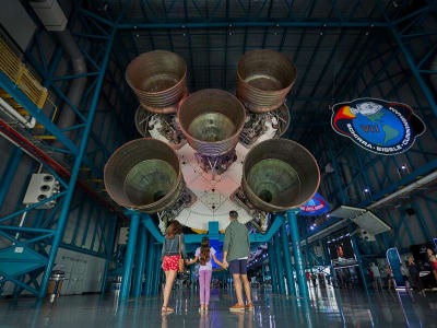 Parents and daughter viewing the Saturn V on display