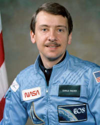 Astronaut Charles Walker with a model of the space shuttle