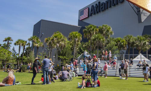 Spectators viewing a rocket launch from the Atlantis North Lawn