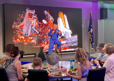 Astronaut talking to a group of visitors siting at a table during Chat With An Astronaut at Kennedy Space Center