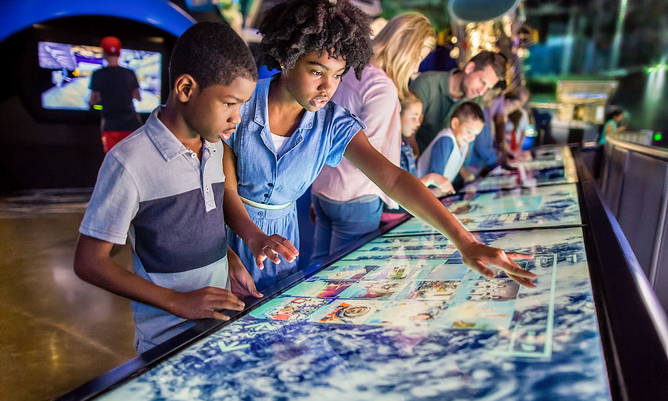 Children playing with the interactive touch screen at the Kennedy Space Center