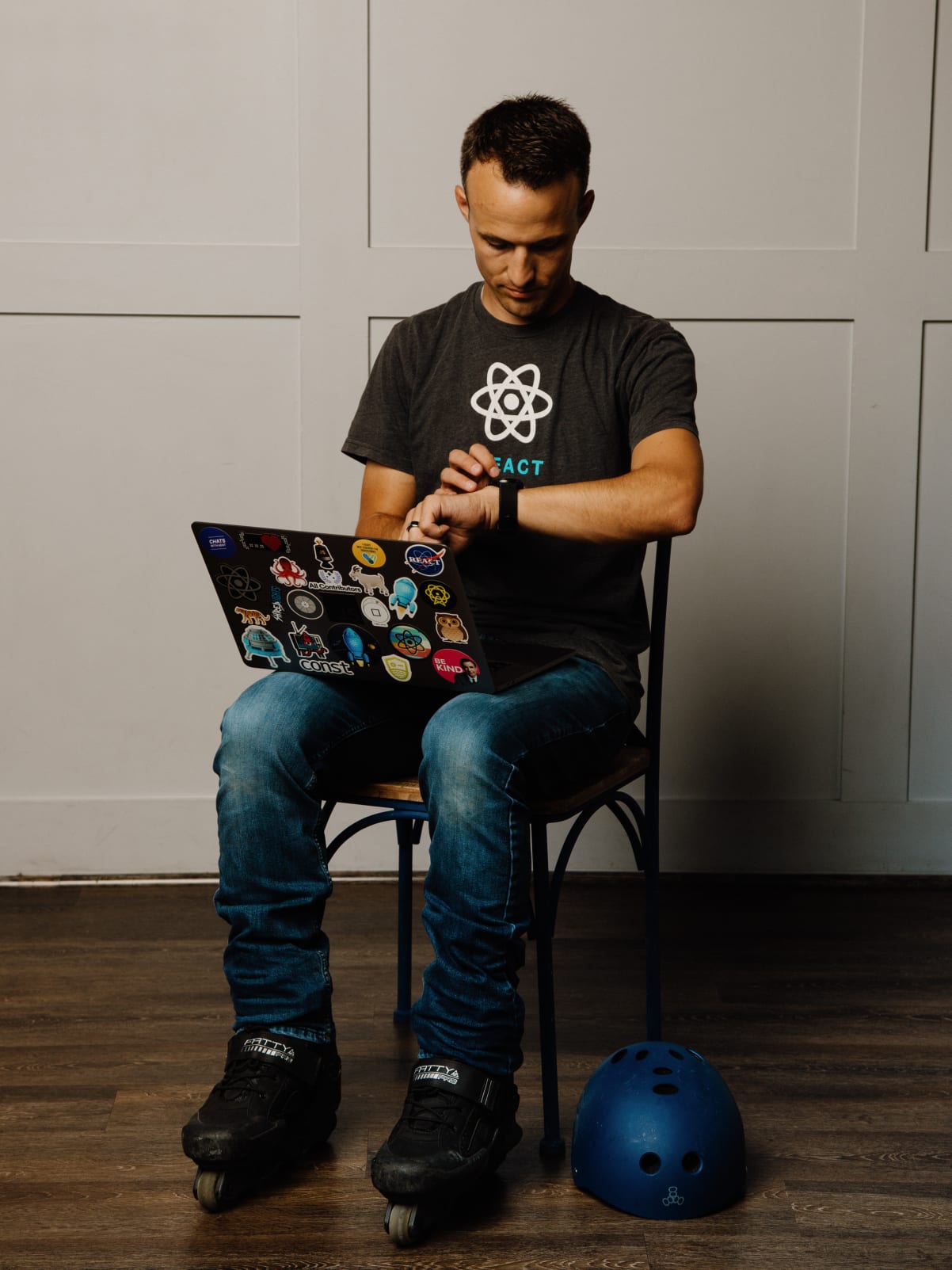 Kent checking his watch while sitting in rollerblades with a laptop