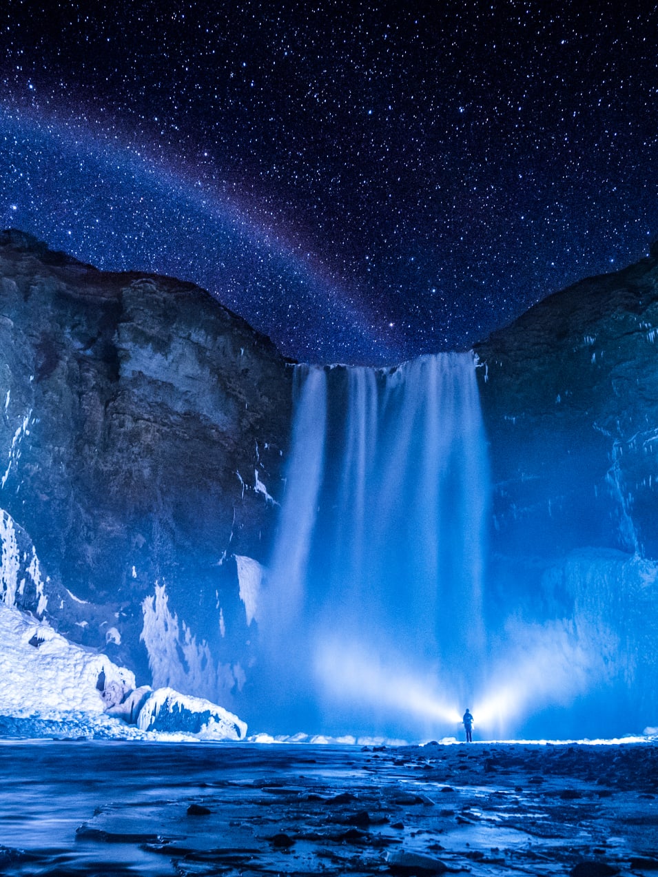 person in front of waterfalls during nighttime