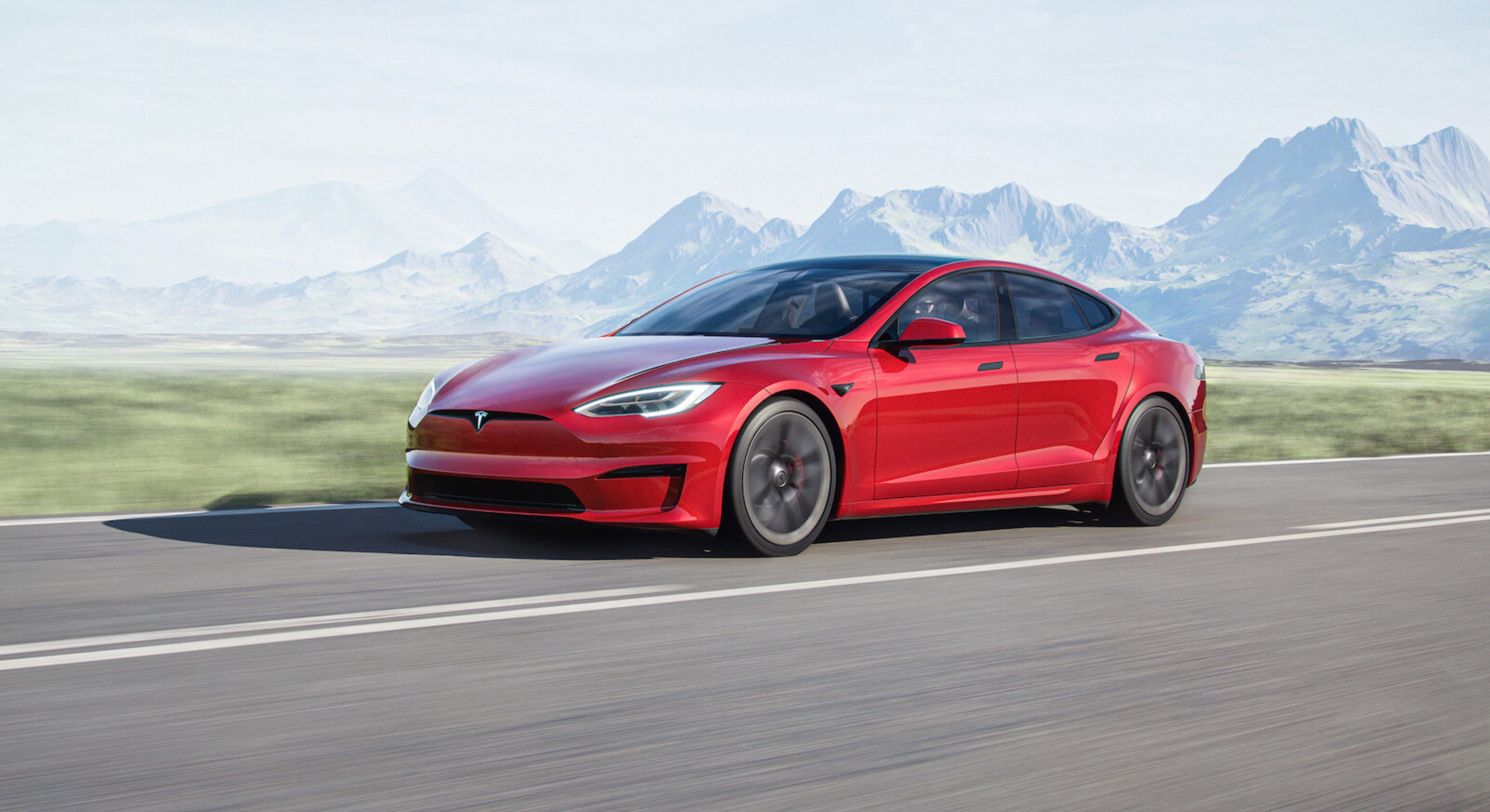 Tesla Model S driving fast with mountains in the background