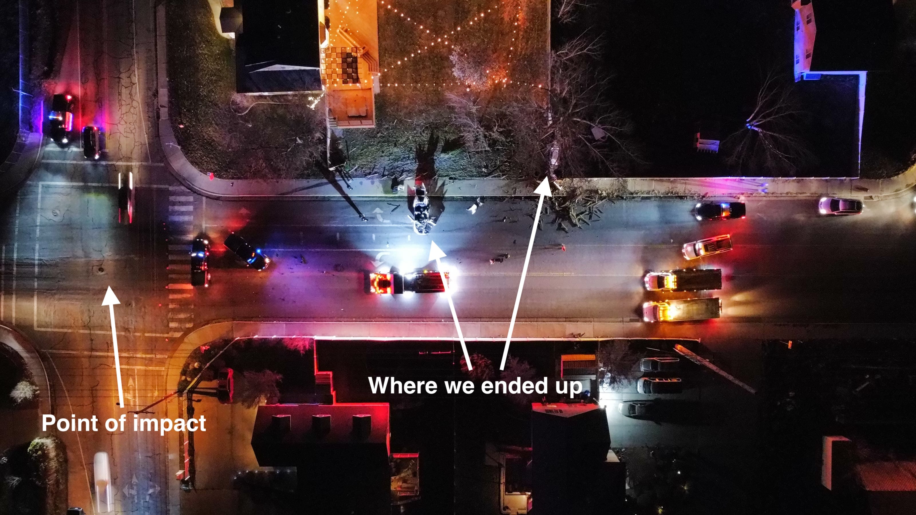 Night-time ariel view of a car accident at a four way stop. Arrows point to the point of impact in the middle of an intersection and where the vehicles ended up over 75 feet away