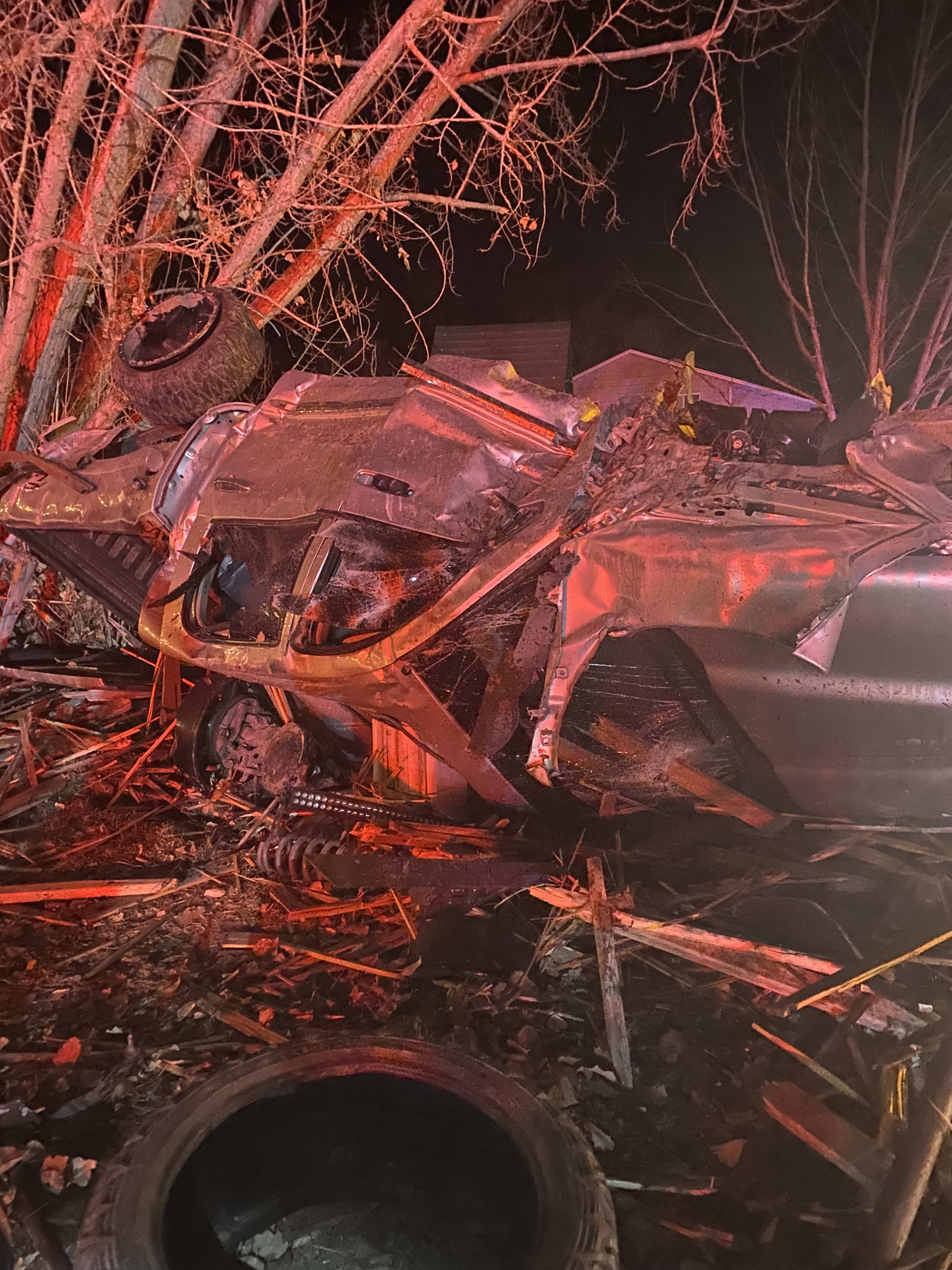 A mangled Dodge Ram 2500 truck up-side-down. It's completely crushed and parts of the truck are strewn about.