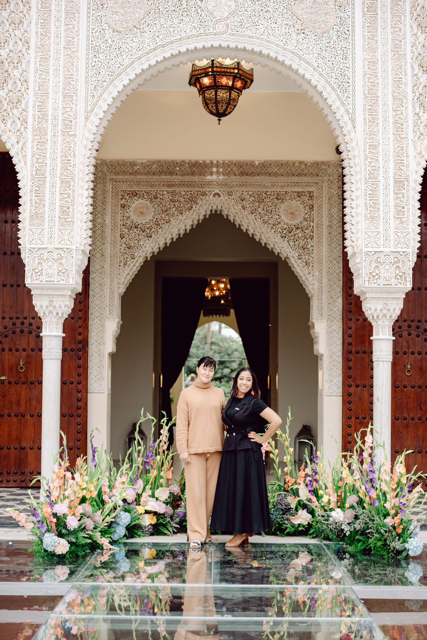 Siham and Maria in a Riad in front of beautiful flowers