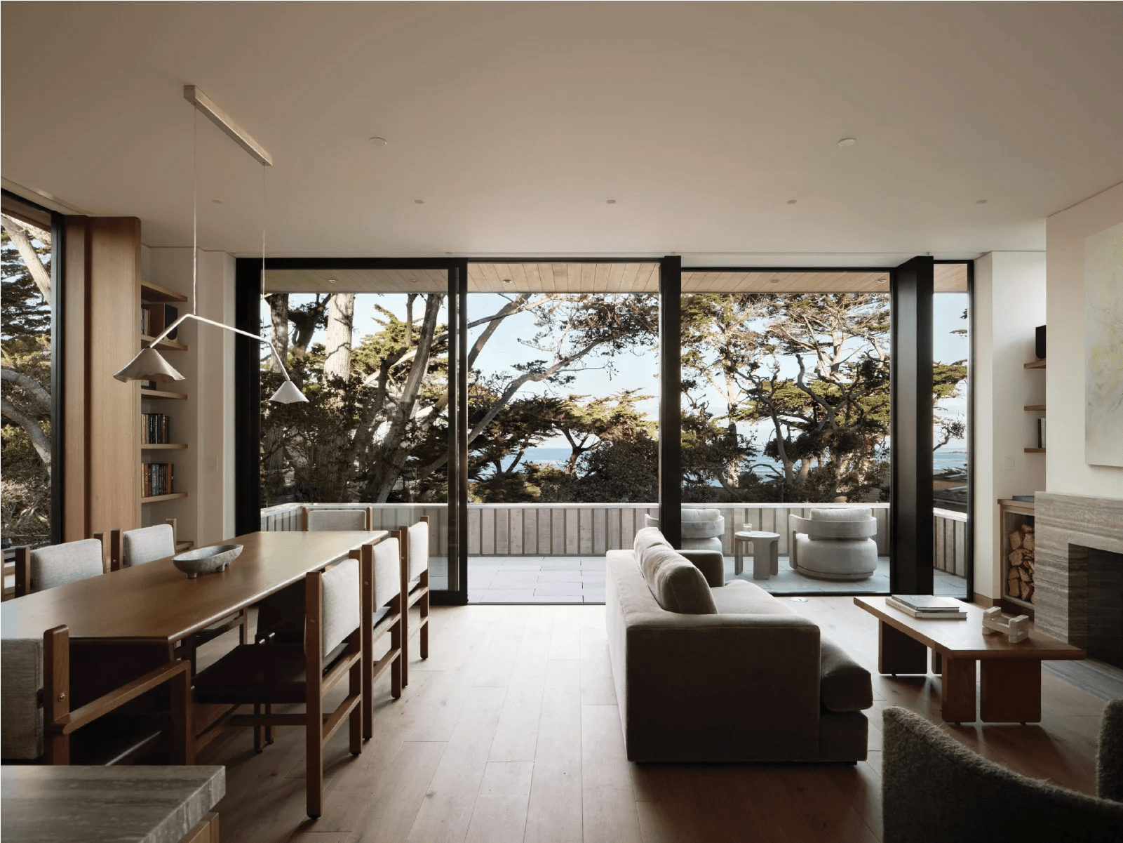 Minimalist Scandinavian coastal living room overlooking ocean cypress trees