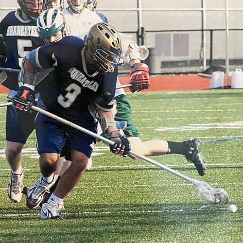 Brennan Buell playing lacrosse outdoors