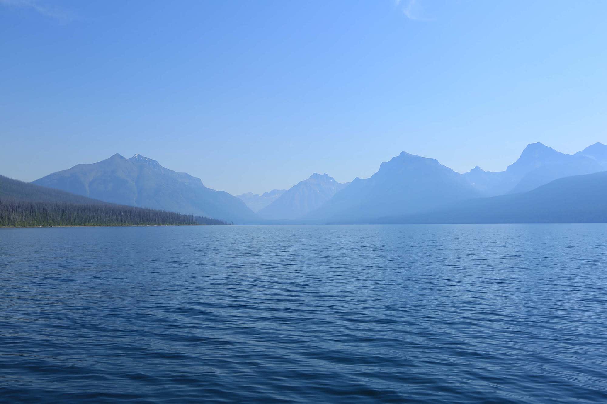 blue lake with mountains overlooking and a blue sky