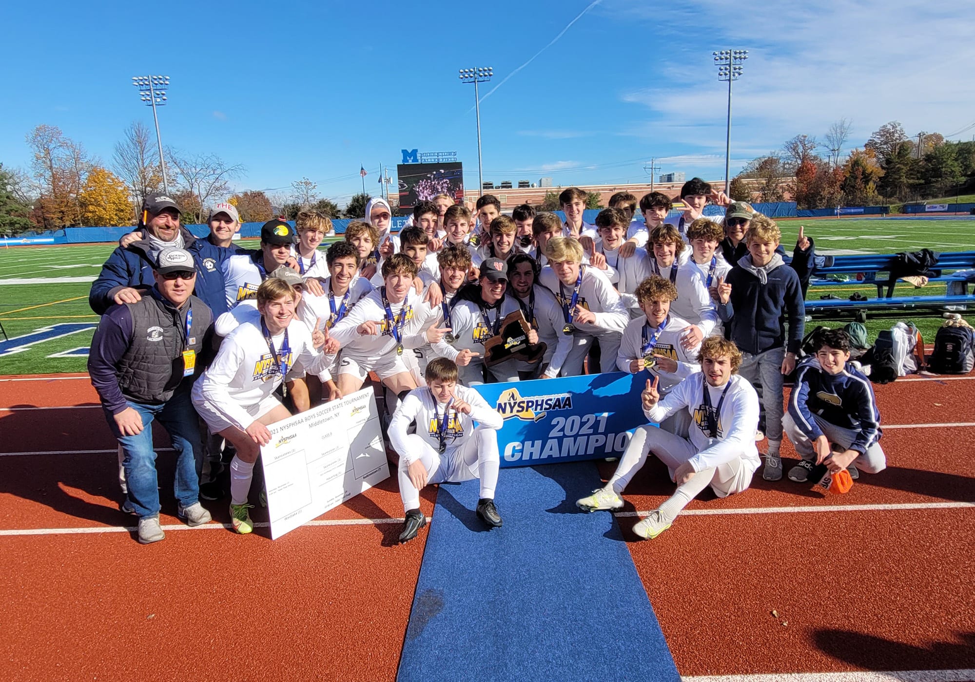 group of young players and their coaches celebrating 2021 nysphsaa soccer championship