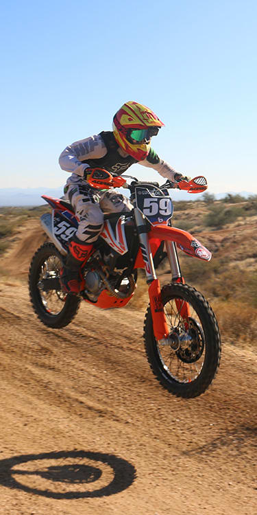 ARITAE Player riding a motorcycle through the desert fast.