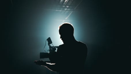 An image of a cameraman in the spotlight