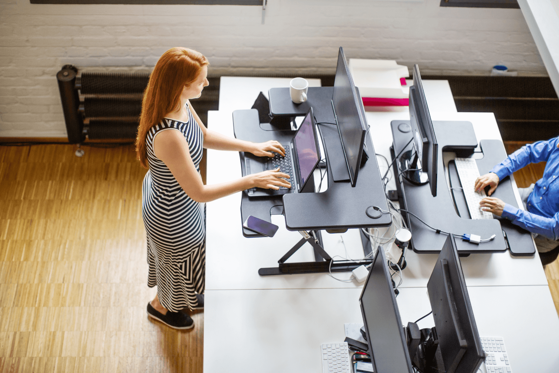 woman working at a standing desk in a coworking space