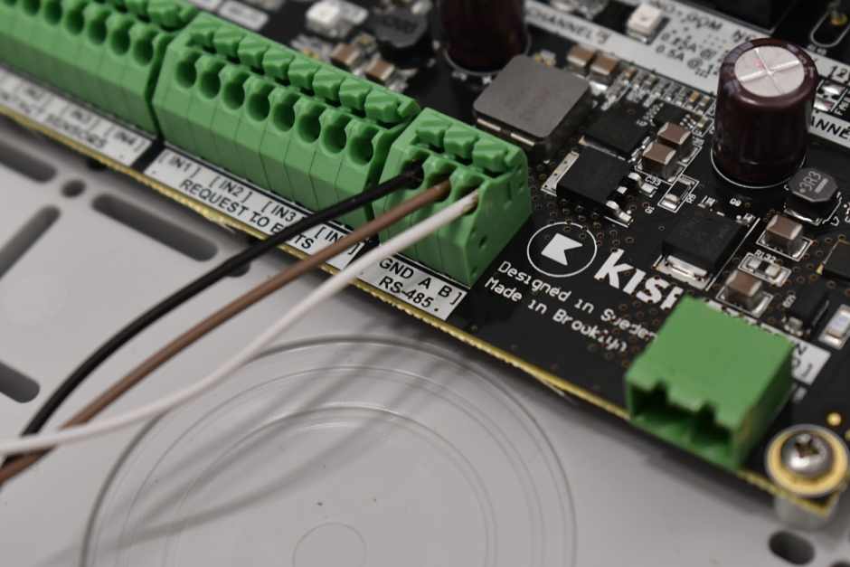 An image of a Kisi access controller wired to a wireless lock gateway