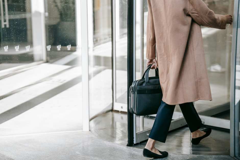 a business woman entering a revolving door